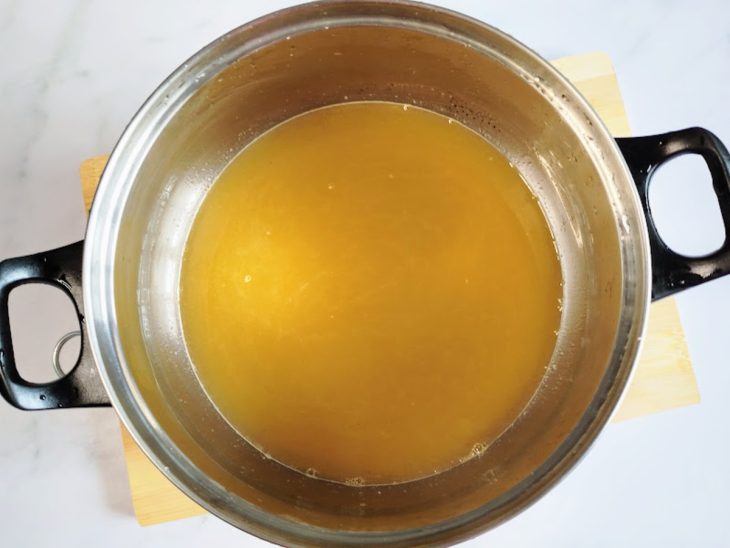 Uma tigela com a mistura de suco de laranja e açúcar.