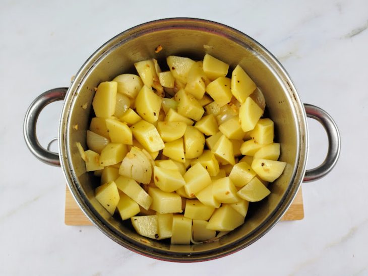 Batatas picadas adicionadas na panela.