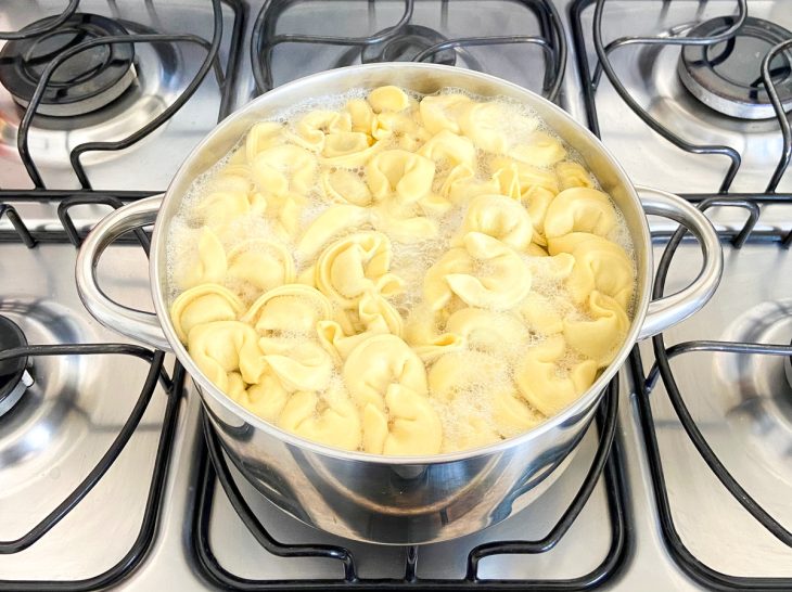 Uma panela com capeletti cozinhando.