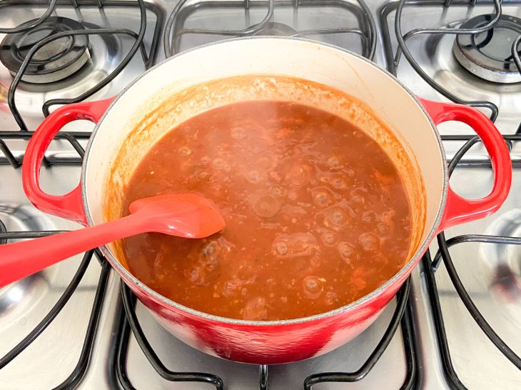 Uma panela ao fogo com a mistura de todos os temperos do molho.