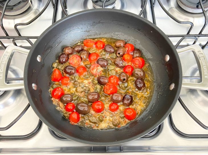 Azeitonas, alcaparras e tomates-cerejas adicionados na frigideira.