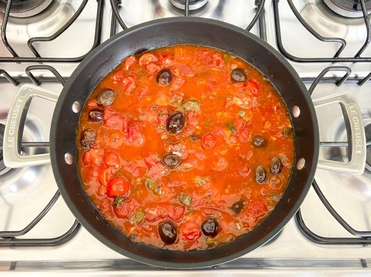 Tomate pelado, salsinha e temperos adicionados na frigideira.