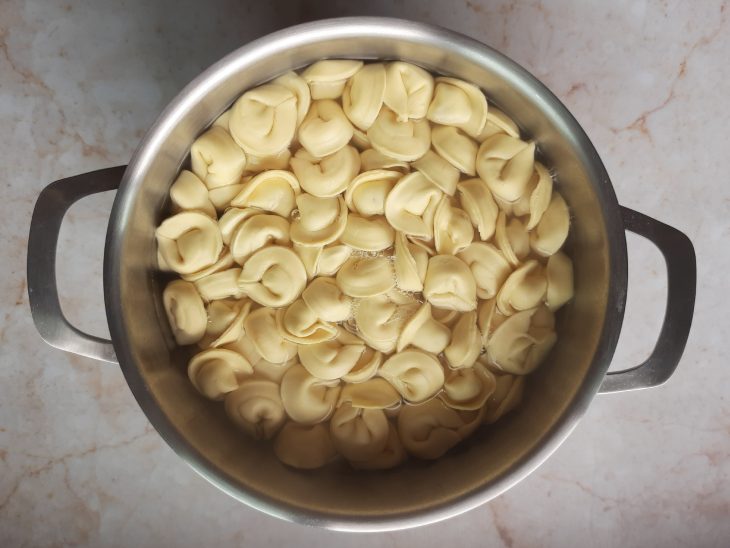 Capeletti de carne em uma panela com água.