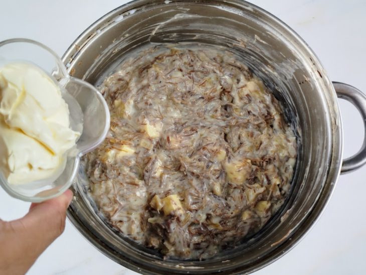 Panela com carne-seca, mistura de leite e amido, manteiga, nata e queijo coalho misturados em uma panela.