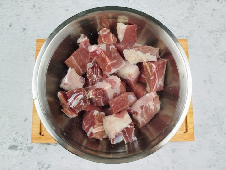 Cubos de carne em uma tigela com água.