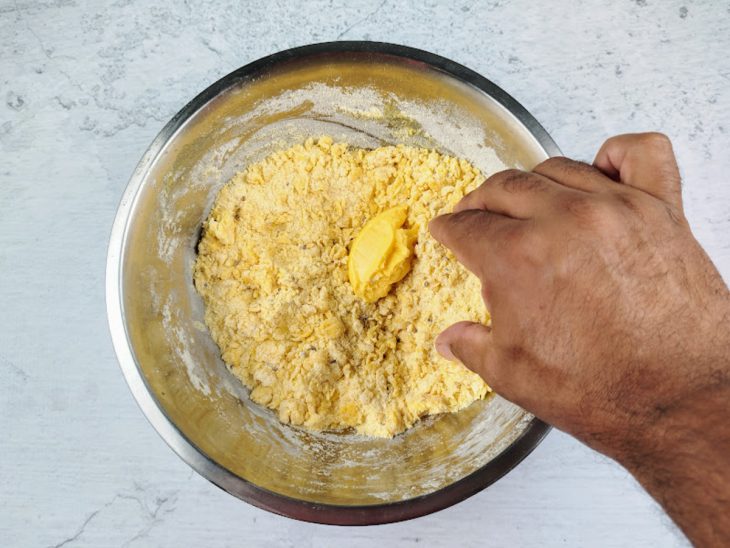 Uma tigela com a mistura de fubá, farinha, açúcar, erva-doce, fermento, ovo e manteiga.