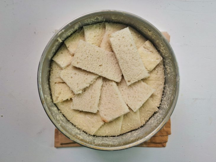 Forma forrada com pães e recheada com a maçã em calda.