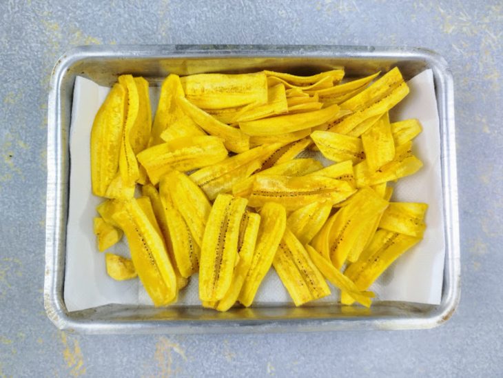 chips de banana-da-terra em uma forma forrada com papel-toalha