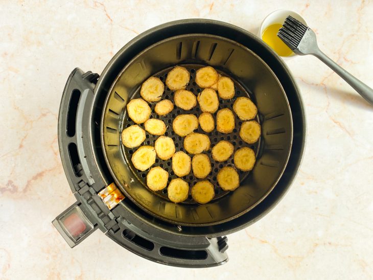 Rodelas de banana espalhadas pela air fryer.