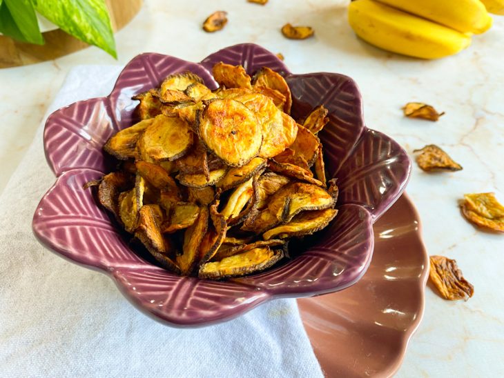 Chips de banana na air fryer servidos em um recipiente.