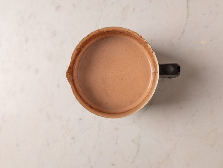 Uma leiteira com o chocolate quente ao ponto.