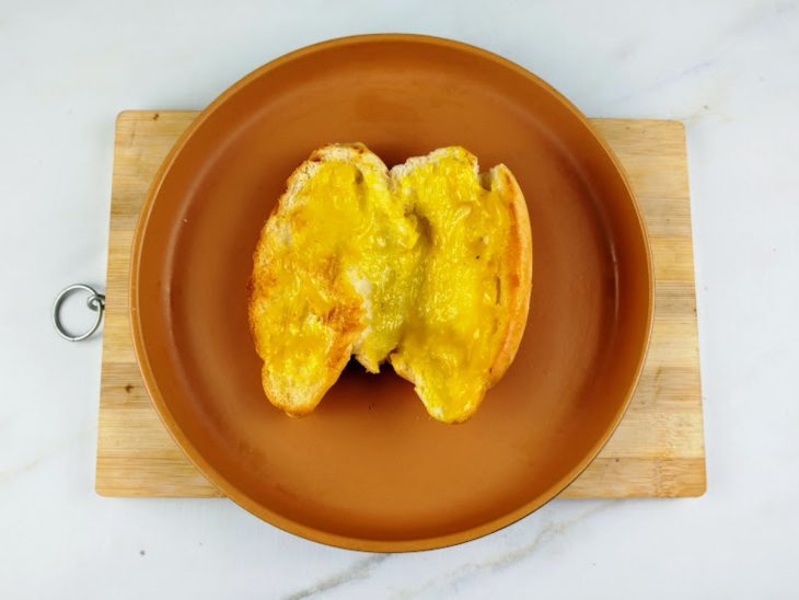 Pão tostado com mostarda pincelada.