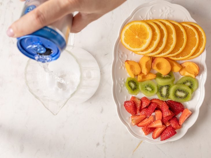 Uma jarra com água tônica e um prato com as frutas ao lado.