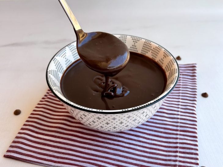 Uma tigela com cobertura de chocolate para bolo.