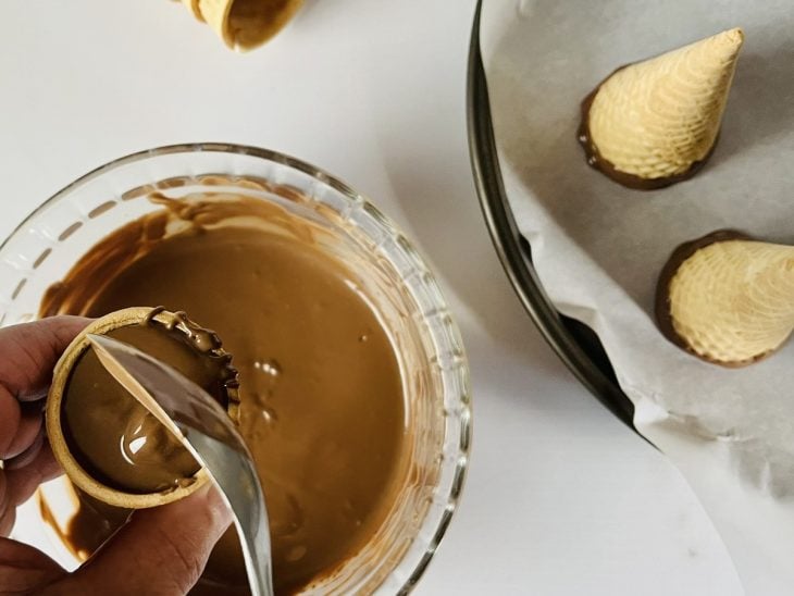 Interior do cone banhado com chocolate derretido.