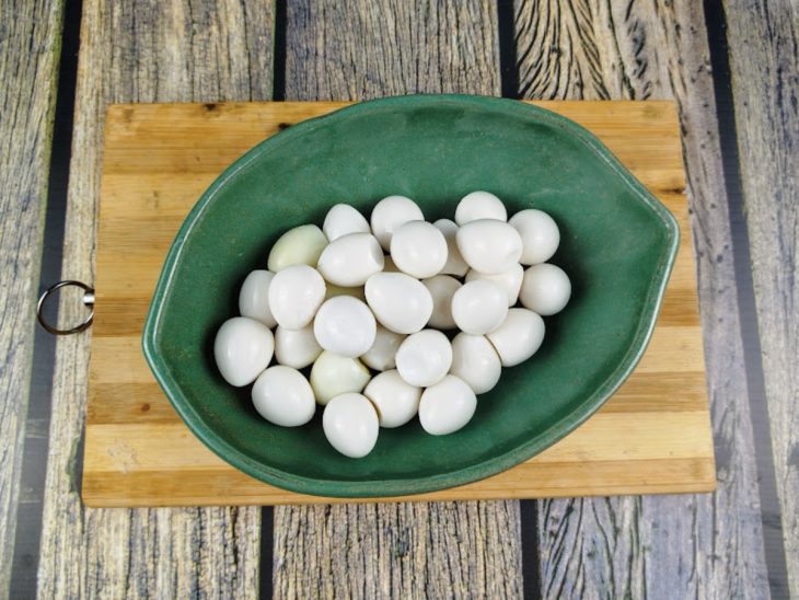 Ovos de codorna descascados e acomodados em um recipiente.