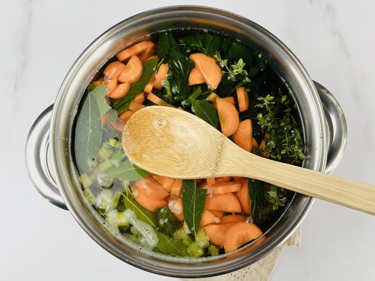 cebola, cenoura, salsão e folhas de louro cozinhando na panela