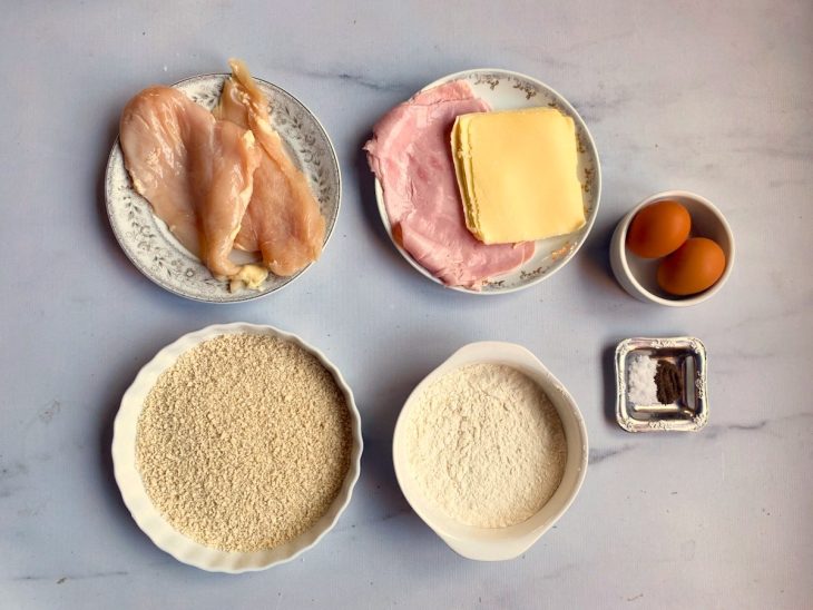 Todos os ingredientes necessários para o preparo do cordon bleu em uma bancada.