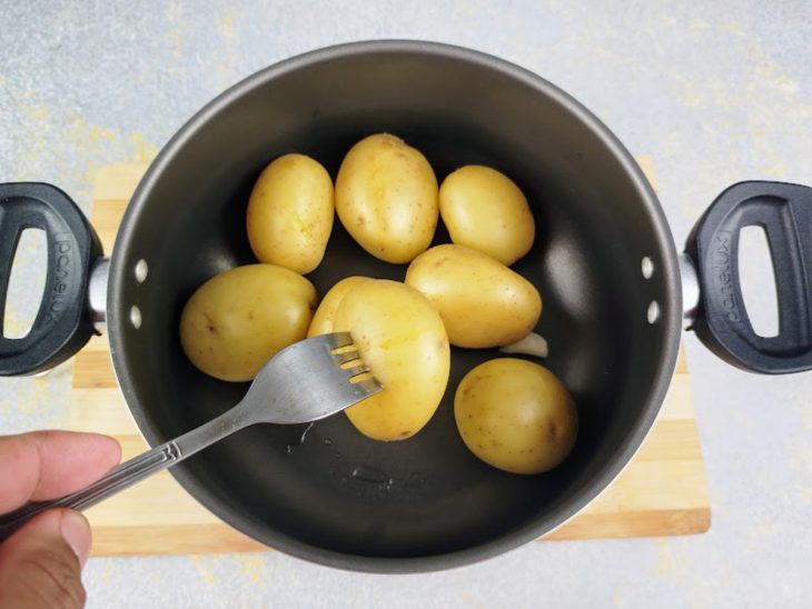 Uma panela com as batatas cozidas.