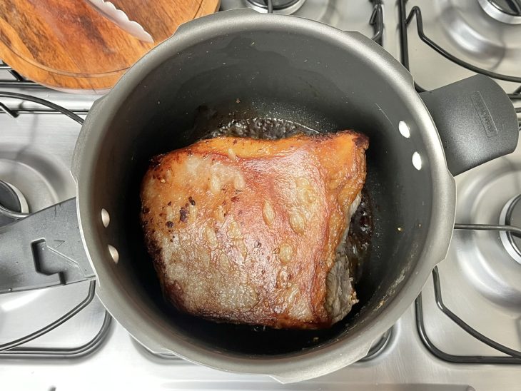 Uma panela de pressão contendo uma peça de coxão mole selada.