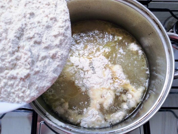 Panela com água borbulhando e farinha peneirada.