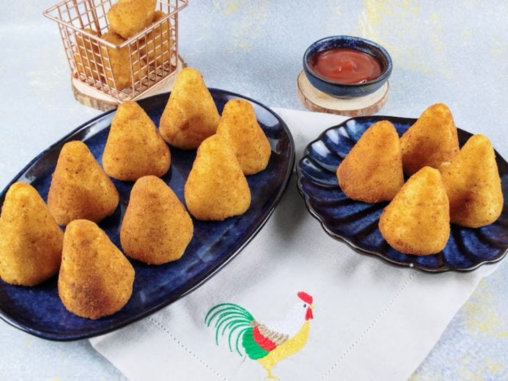 Coxinha de frango servida com ketchup.