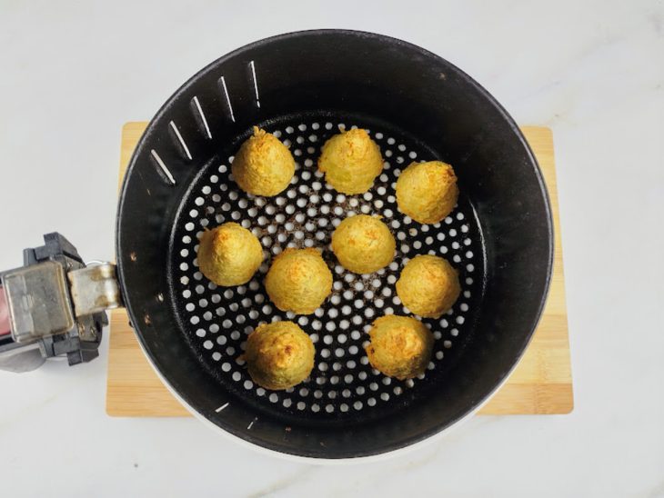 Cesto de uma air fryer com as coxinhas após assar.