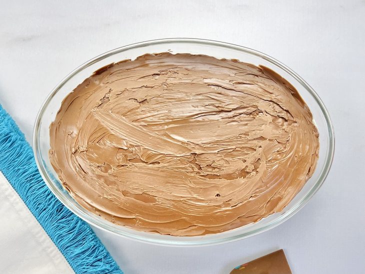Um refratário contendo creme de cupuaçu coberto com chocolate.