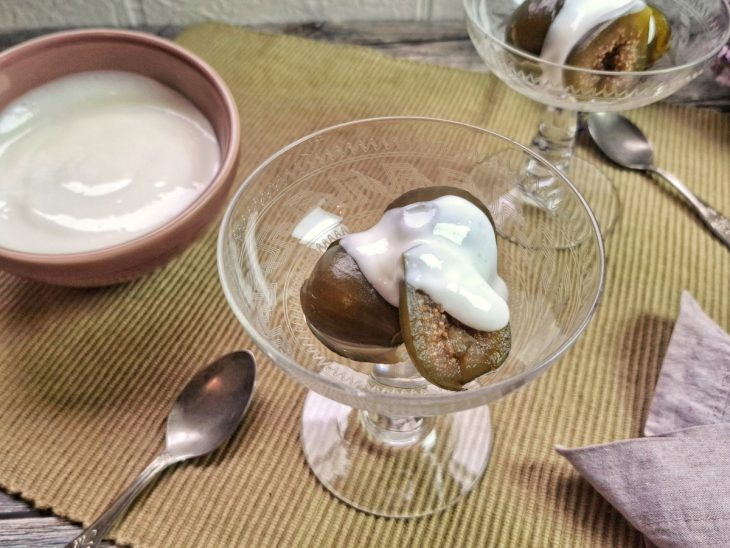 Creme de leite colocado por cima dos figos em uma taça.