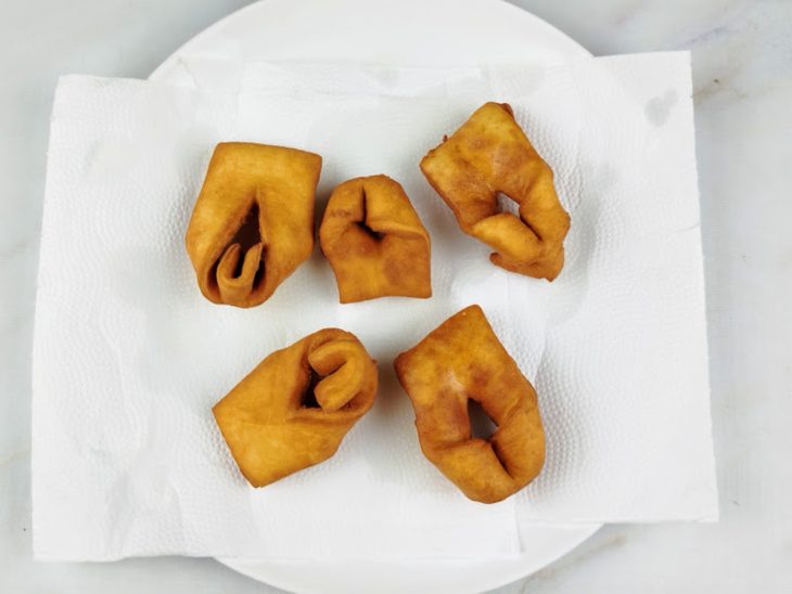 Cuecas viradas fritas sobre um prato forrado com papel-toalha.