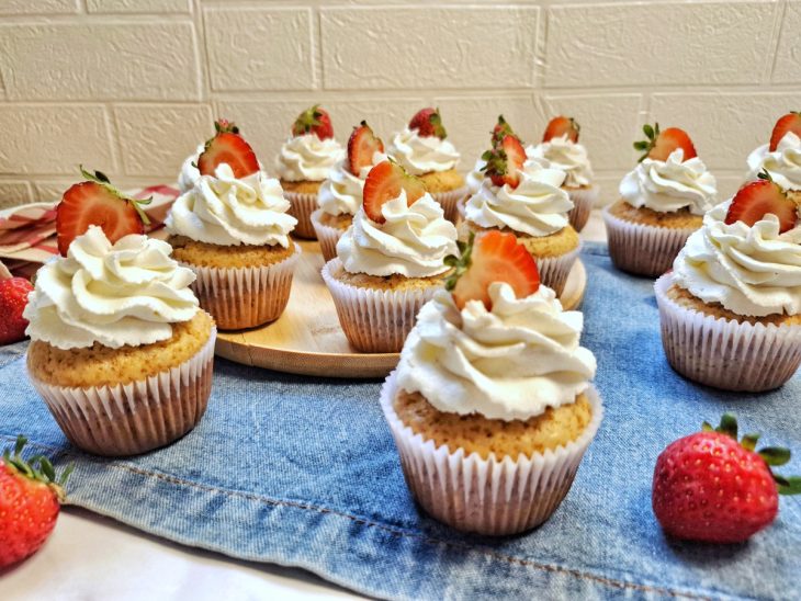 Cupcakes rápidos finalizados com morangos, prontos para consumo.