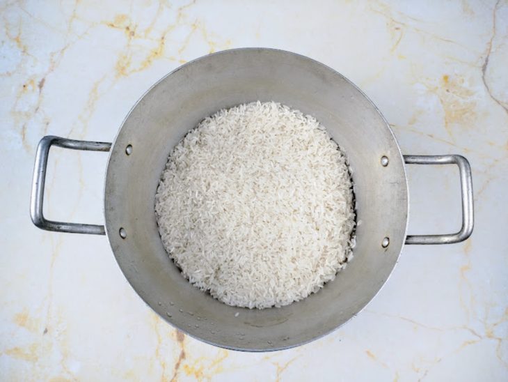 Uma panela com arroz lavado.