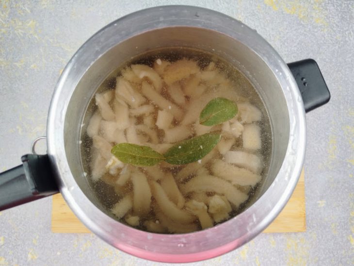 Uma panela com tiras de bucho em água fervente.