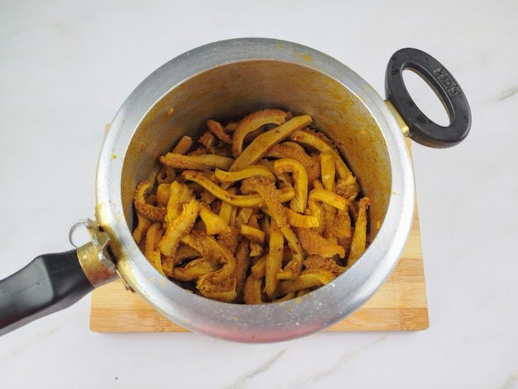 Uma panela de pressão com o bucho e os temperos refogados.