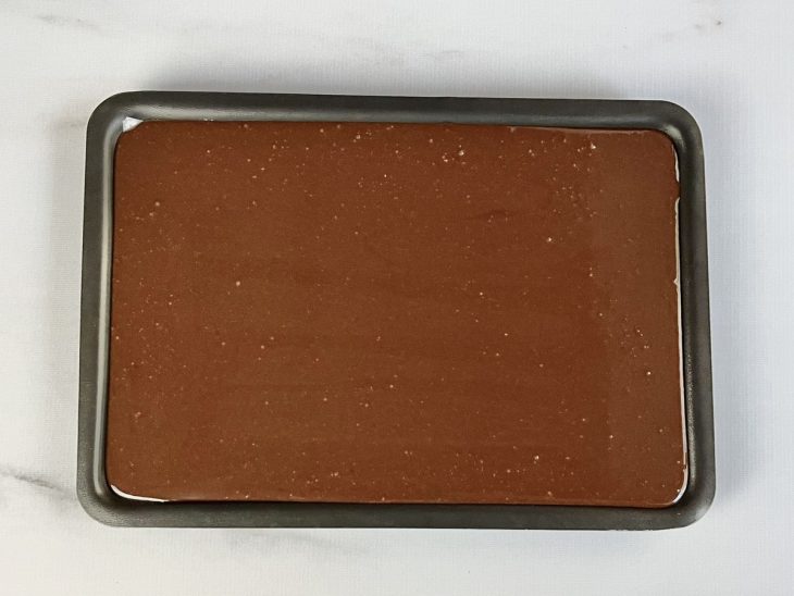 Doce de chocolate despejado na assadeira