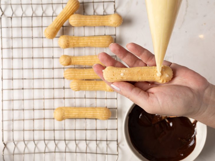 Éclair recheada com saco de confeitar.