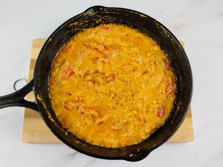 Uma frigideira com a mistura do camarão refogado e o caldo batido no liquidificador.