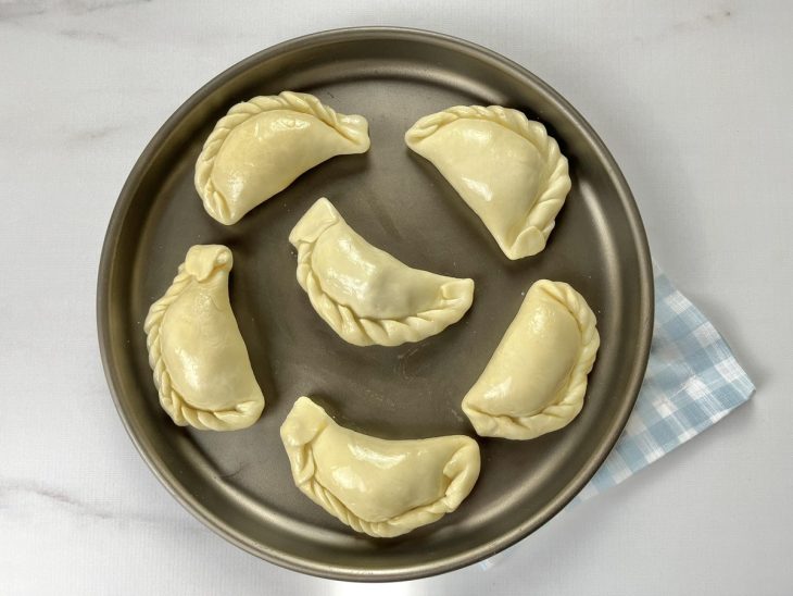 Uma assadeira com empanadas de frango.