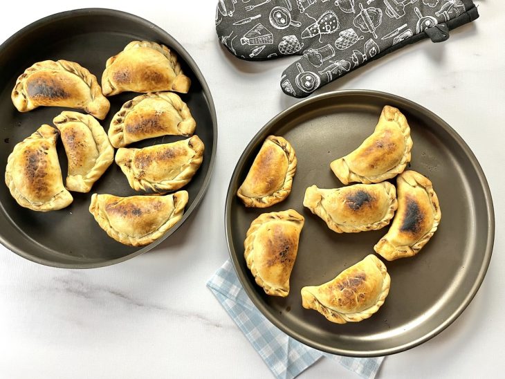 Uma assadeira com empanadas de frango.