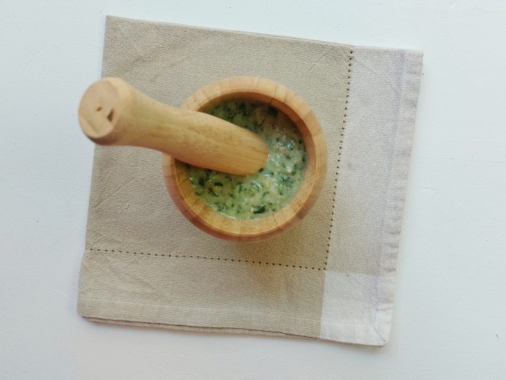 Um recipiente com molho pesto.