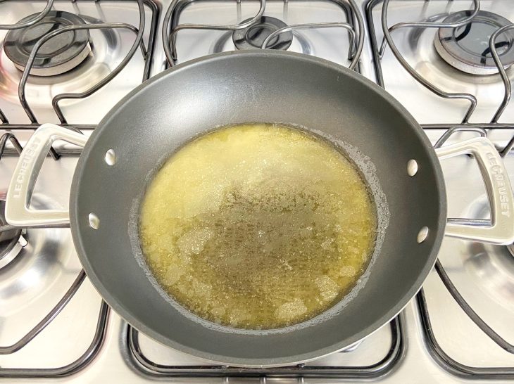 Uma panela com margarina derretida em um fogão.