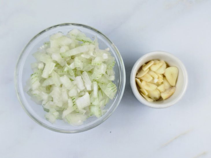 Recipientes com cebola e alho picados.