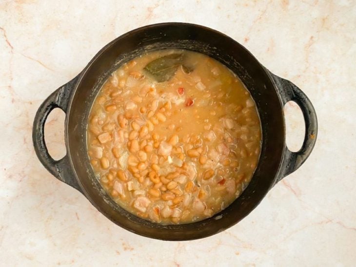 Refogado adicionado ao feijão cozido temperado com sal e pimenta-do-reino.