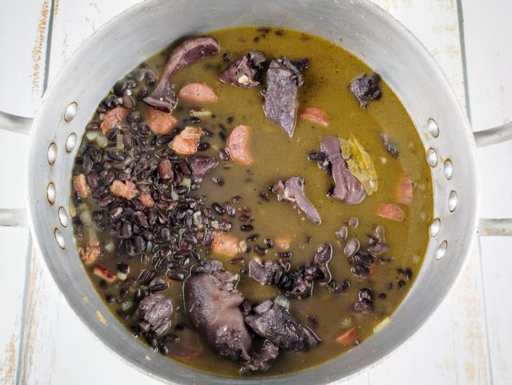 Uma panela com a mistura de todos os ingredientes da feijoada.