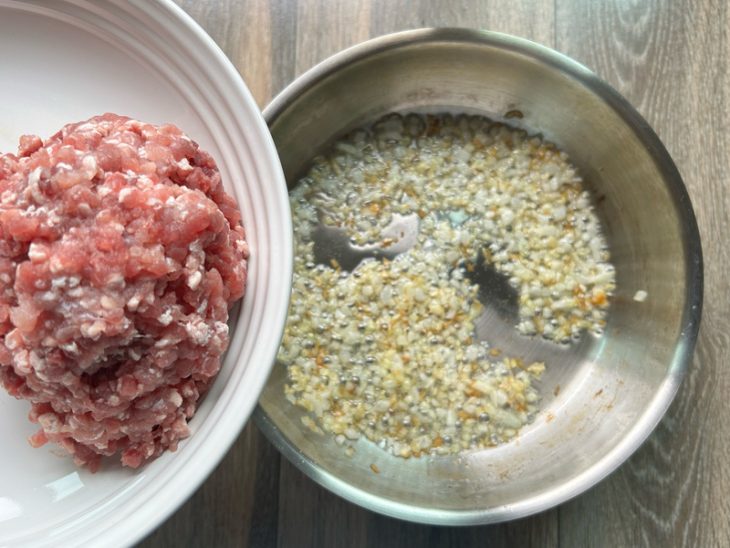 Panela com alho e cebola, e recipiente com carne moída.