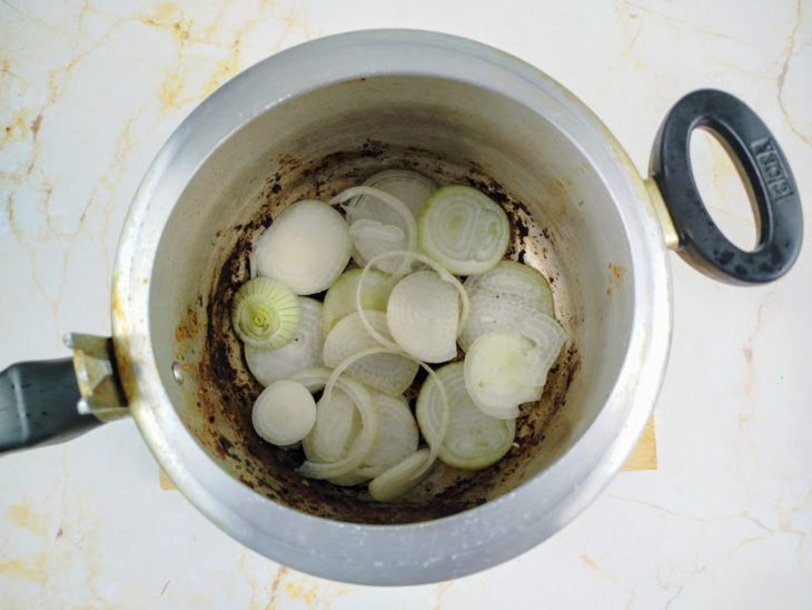 Uma panela de pressão com uma camada de cebola.