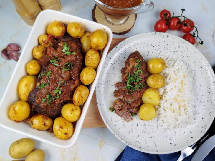 Um refratário e um prato contendo fraldinha na pressão com batata.