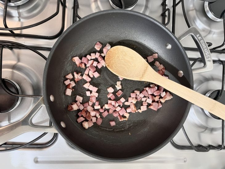 Cubos de bacon em uma frigideira.