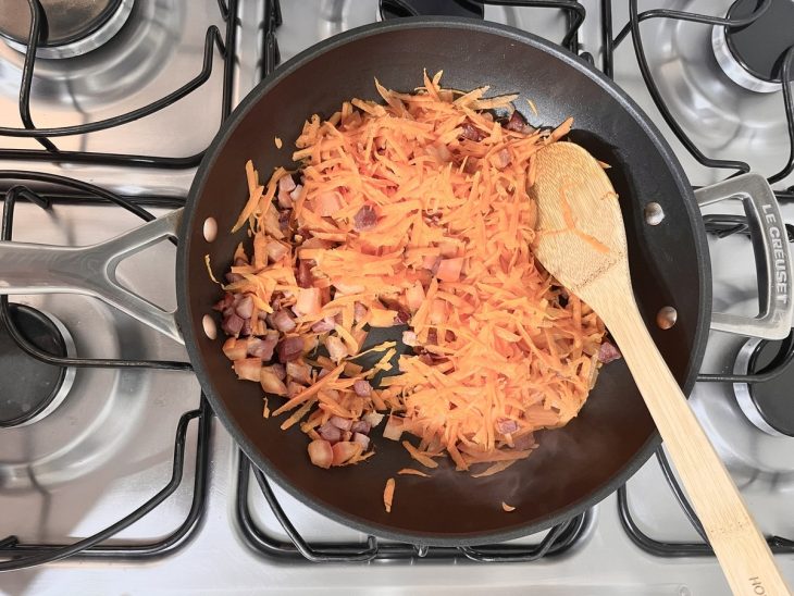 Cenoura e tomate adicionado na frigideira com bacon e cebola.