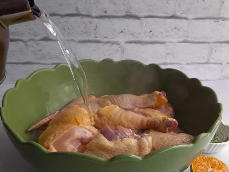 Uma tigela com frango e água quente.